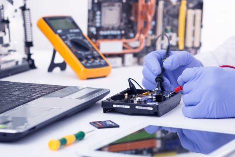 photo d'un professionnel de la réparation qui opère une micro soudure sur les composants CMS d'une carte électronique